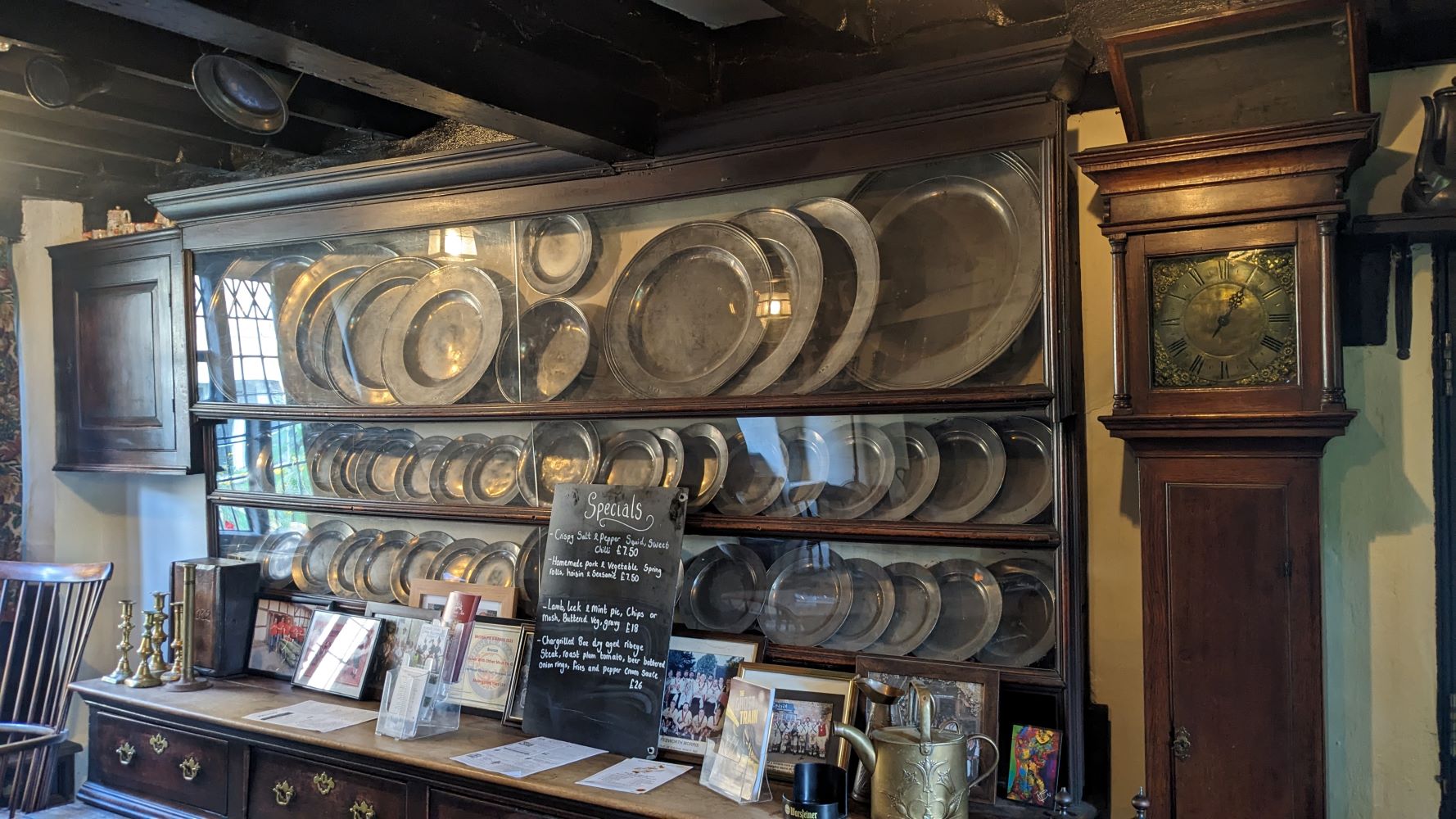 Dresser crammed with 3 shelves of dull metal plates