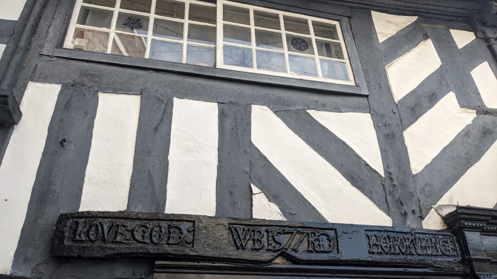 A photograph of an inscription on the front of King Charles House, The Cornmarket which reads Love God Honour Ye Kinge dated to 1577.