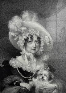 Black and white image of a woman wearing a large extravagant hat holding her dog